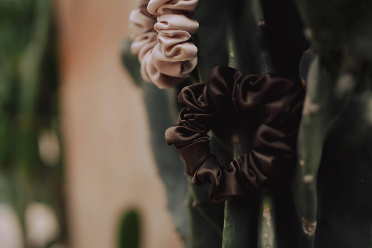 Close-up of medium silk scrunchies in coffee and champagne